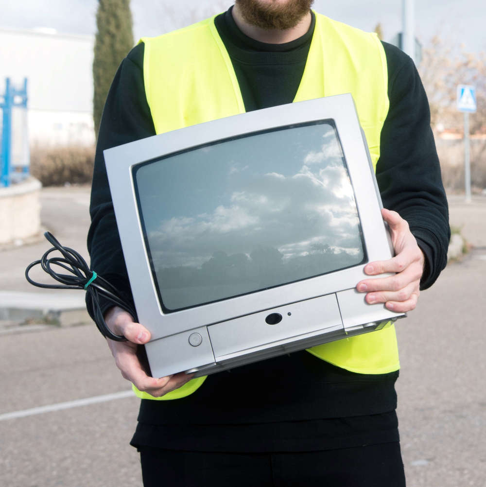 Image of one of our team members recycling a television in Boston MA